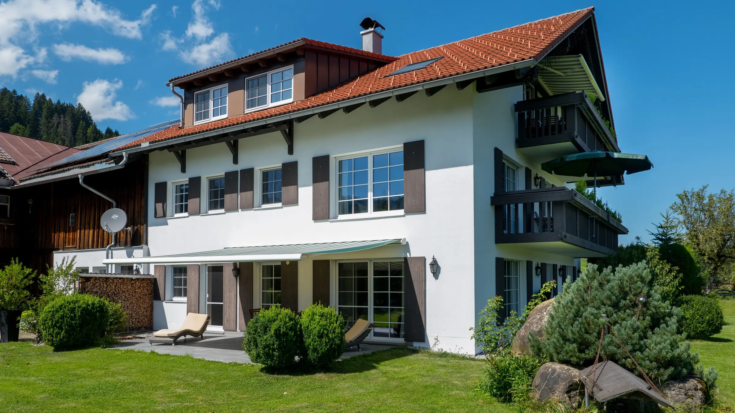 AlpenLodge Allgäu Außenansicht Wohnflügel im Sommer